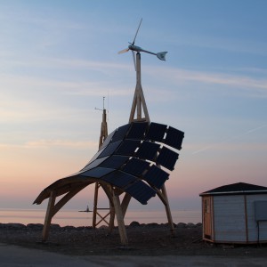 Giraffe 2.0 wind turbine and solar PV on wooden construction at sunset