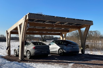 Wooden solar carport with two cars parked underneath
